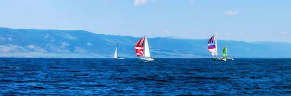 Yacht regatta met een kleur zeil in een mistige ochtend drijft op de zee. Breed panorama Stockfoto