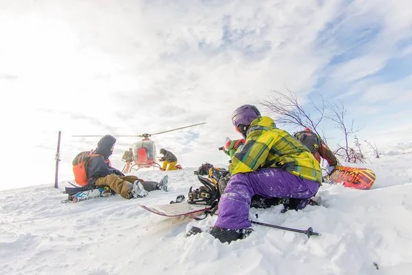 Aterragem a partir do helicóptero esquiadores freeriders nas montanhas nevadas no inverno — Fotografia de Stock