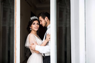 Gelin ve damat büyük bir pencere duran.