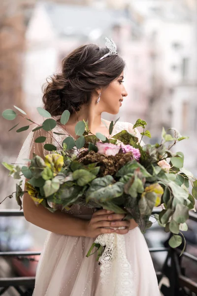 Noiva com um buquê de flores na varanda — Fotografia de Stock