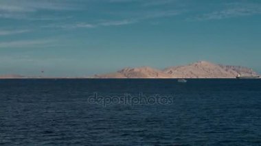 Deniz ve dağlar timelapse güzel bir akşam peyzaj dinamik yakınlaştırma. Akşam Kızıldeniz manzarası. Denizde tekne. Deniz zaman atlamalı 4 k gemi