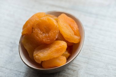 Kuru Kayısı beyaz bir arka plan üzerinde kahverengi plaka. Yakın çekim