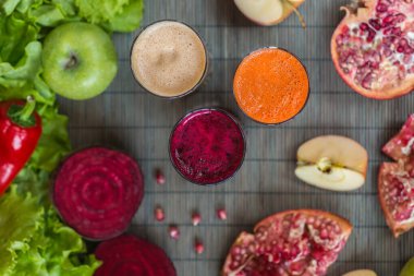 farklı taze meyve suyu üç bardak. Pancar, havuç ve elma suyu gri ahşap zemin üzerine