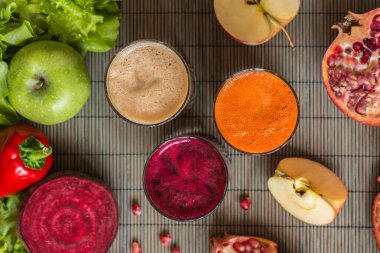 farklı taze meyve suyu üç bardak. Pancar, havuç ve elma suyu gri ahşap zemin üzerine