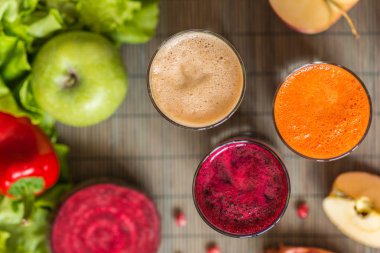farklı taze meyve suyu üç bardak. Pancar, havuç ve elma suyu gri ahşap zemin üzerine