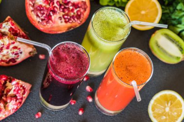 farklı taze meyve suyu üç bardak. Gri arka plan üzerinde pancar, havuç ve kivi meyve suları