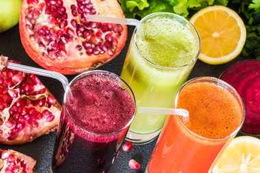 farklı taze meyve suyu üç bardak. Gri arka plan üzerinde pancar, havuç ve kivi meyve suları