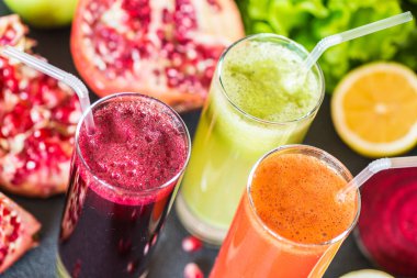 farklı taze meyve suyu üç bardak. Gri arka plan üzerinde pancar, havuç ve kivi meyve suları