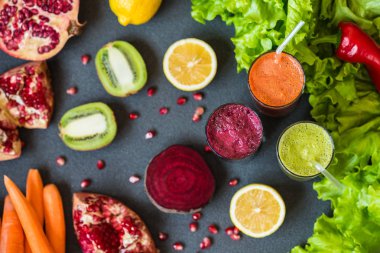 farklı taze meyve suyu üç bardak. Gri arka plan üzerinde pancar, havuç ve kivi meyve suları