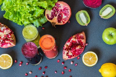 farklı taze meyve suyu üç bardak. Gri arka plan üzerinde pancar, havuç ve kivi meyve suları