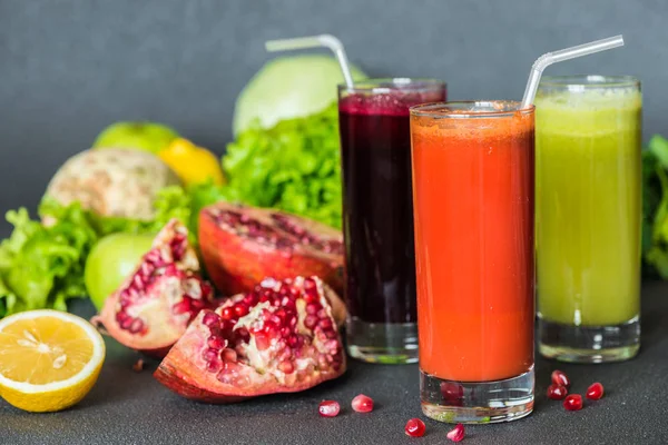 Tre glas av olika färsk juice. Rödbetor, morot och kiwi juice på grå bakgrund — Stockfoto