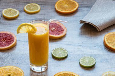 ahşap zemin üzerine portakal suyu bir bardak limon dilimleri ile