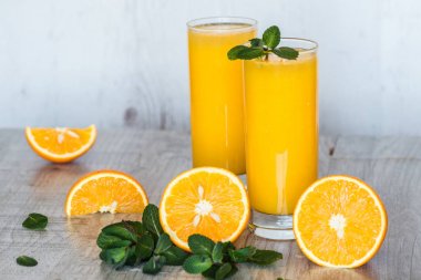 Gözlüklü hafif ahşap arka plan, nane ile portakal suyu