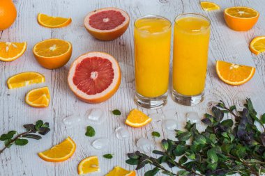 narenciye yakın gözlük ve nane hafif ahşap arka plan, buz ile portakal suyu