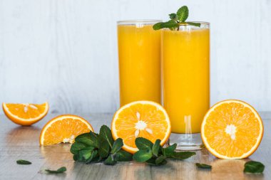 Gözlüklü hafif ahşap arka plan, nane ile portakal suyu