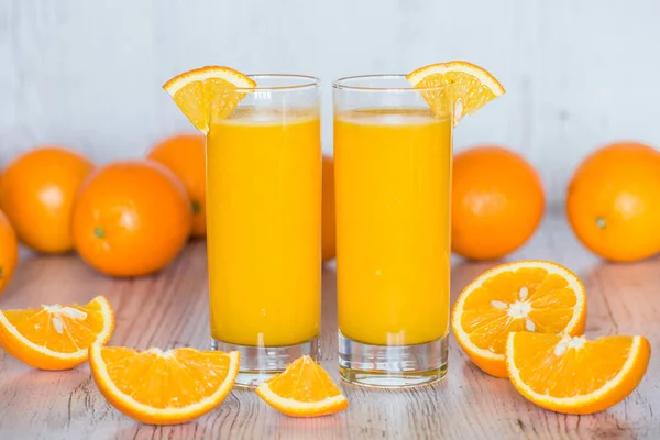 Zumo de naranja en vasos en fondo de madera claro —  Fotos de Stock