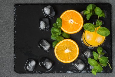 cam narenciye yakınındaki, buz ve koyu arka plan üzerine nane portakal suyu