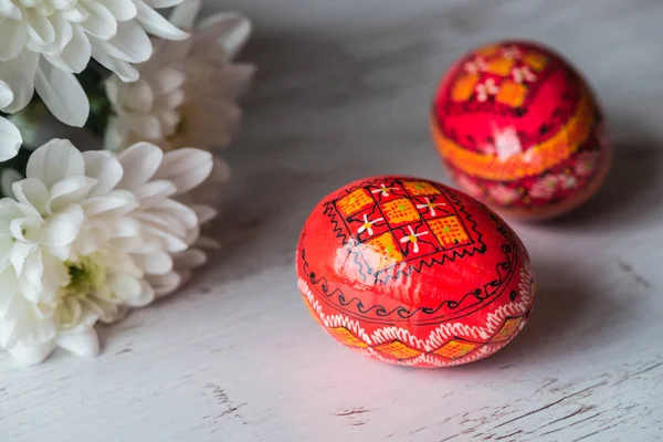 Sfondo pasquale con uova di Pasqua e fiori primaverili su sfondo di legno chiaro — Foto Stock