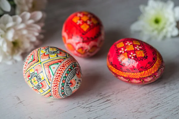 Fond de Pâques avec des œufs de Pâques et des fleurs de printemps sur fond en bois clair — Photo