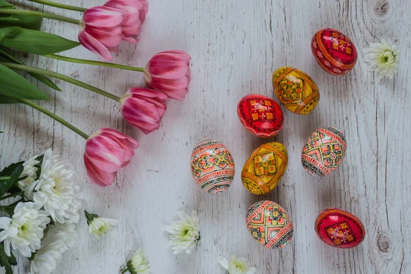 Easter Background with easter eggs and pink tulips on light wooden background — Stock Photo, Image