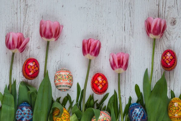 Sfondo pasquale con uova di Pasqua e tulipani rosa su erba verde — Foto Stock