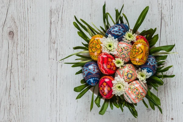 Sfondo pasquale con uova di Pasqua e fiori primaverili su erba verde — Foto Stock