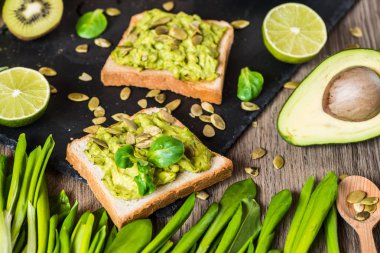 Sağlıklı yeşil yiyecek. Avokado ve ahşap arka plan üzerinde sebze vejetaryen sandviç.
