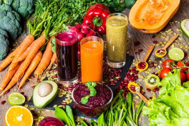 Sağlıklı vegan gıda. Ahşap arka plan üzerinde taze sebze. Detoks diyet. Farklı renkli taze meyve suları