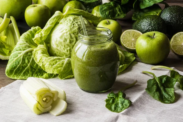 Diety detoks. Zielony koktajl z różnych warzyw na podłoże drewniane — Zdjęcie stockowe
