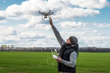 adam yeşil alan, uçan uçak quadrocopter tutan