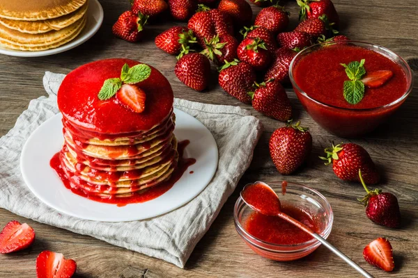 Crêpes américaines et sauce aux fraises sur fond de bois. Grande profondeur de champ . — Photo