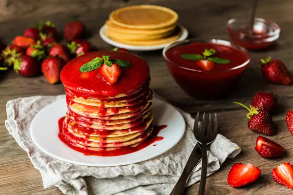 Crêpes américaines et sauce aux fraises sur fond de bois. Profondeur de champ faible . — Photo