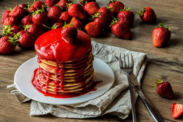 Close-up Amerikaanse pannenkoeken met aardbei jam op een houten achtergrond. Grote scherptediepte. — Stockfoto