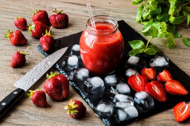 Taze çilek ve siyah bir taş tahta üzerinde buz ile çilek güler yüzlü