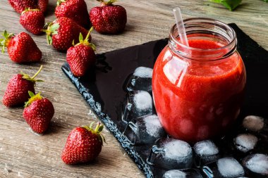 Taze çilek ve siyah bir taş tahta üzerinde buz ile çilek güler yüzlü