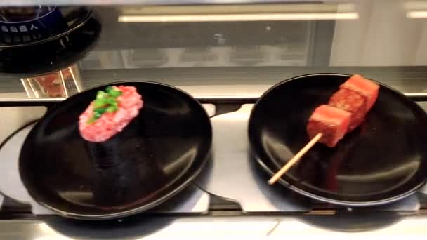 Конвейерная лента суши. Поднос для суши на конвейере в ресторане — стоковое видео
