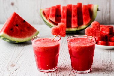 sağlıklı içecekler. Beyaz ahşap zemin üzerinde bir kalp ile karpuz güler yüzlü