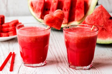 sağlıklı içecekler. Beyaz ahşap zemin üzerinde bir kalp ile karpuz güler yüzlü