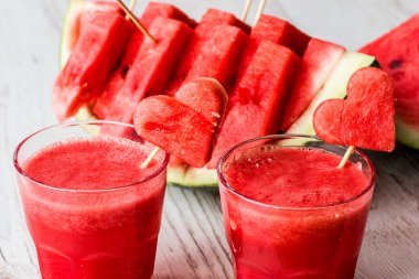 sağlıklı içecekler. Beyaz ahşap zemin üzerinde bir kalp ile karpuz güler yüzlü