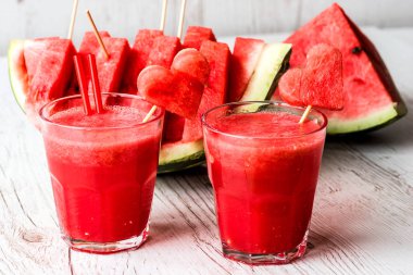 sağlıklı içecekler. Beyaz ahşap zemin üzerinde bir kalp ile karpuz güler yüzlü