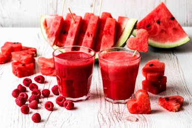 sağlıklı içecekler. karpuz ve ahududu güler yüzlü beyaz ahşap zemin üzerinde