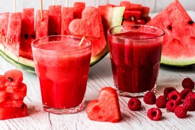 sağlıklı içecekler. karpuz ve ahududu güler yüzlü beyaz ahşap zemin üzerinde