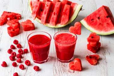 sağlıklı içecekler. karpuz ve ahududu güler yüzlü beyaz ahşap zemin üzerinde