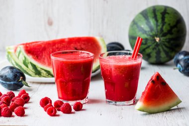 sağlıklı içecekler. Beyaz ahşap zemin üzerinde karpuz ve ahududu smoothies