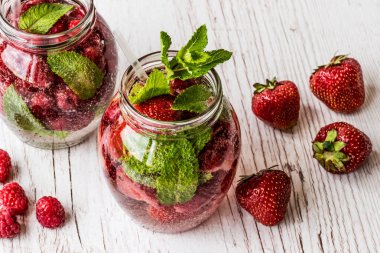 Su Beyaz ahşap zemin üzerinde çilek ile detoks. Sağlıklı içecekler