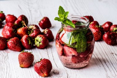 Su Beyaz ahşap zemin üzerinde çilek ile detoks. Sağlıklı içecekler