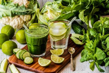 Yeşil smoothie ve detoks su kireç, nane ve buz üzerinde ahşap arka plan ile. Detoks Diyeti.