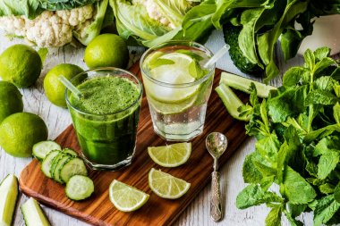 Yeşil smoothie ve detoks su kireç, nane ve buz üzerinde ahşap arka plan ile. Detoks Diyeti.