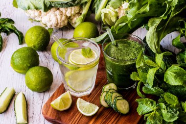 Yeşil smoothie ve detoks su kireç, nane ve buz üzerinde ahşap arka plan ile. Detoks Diyeti.