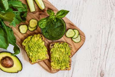 Üstten Görünüm. Yeşil smoothie ve avokado ile iki sandviç. sağlıklı vegan gıda